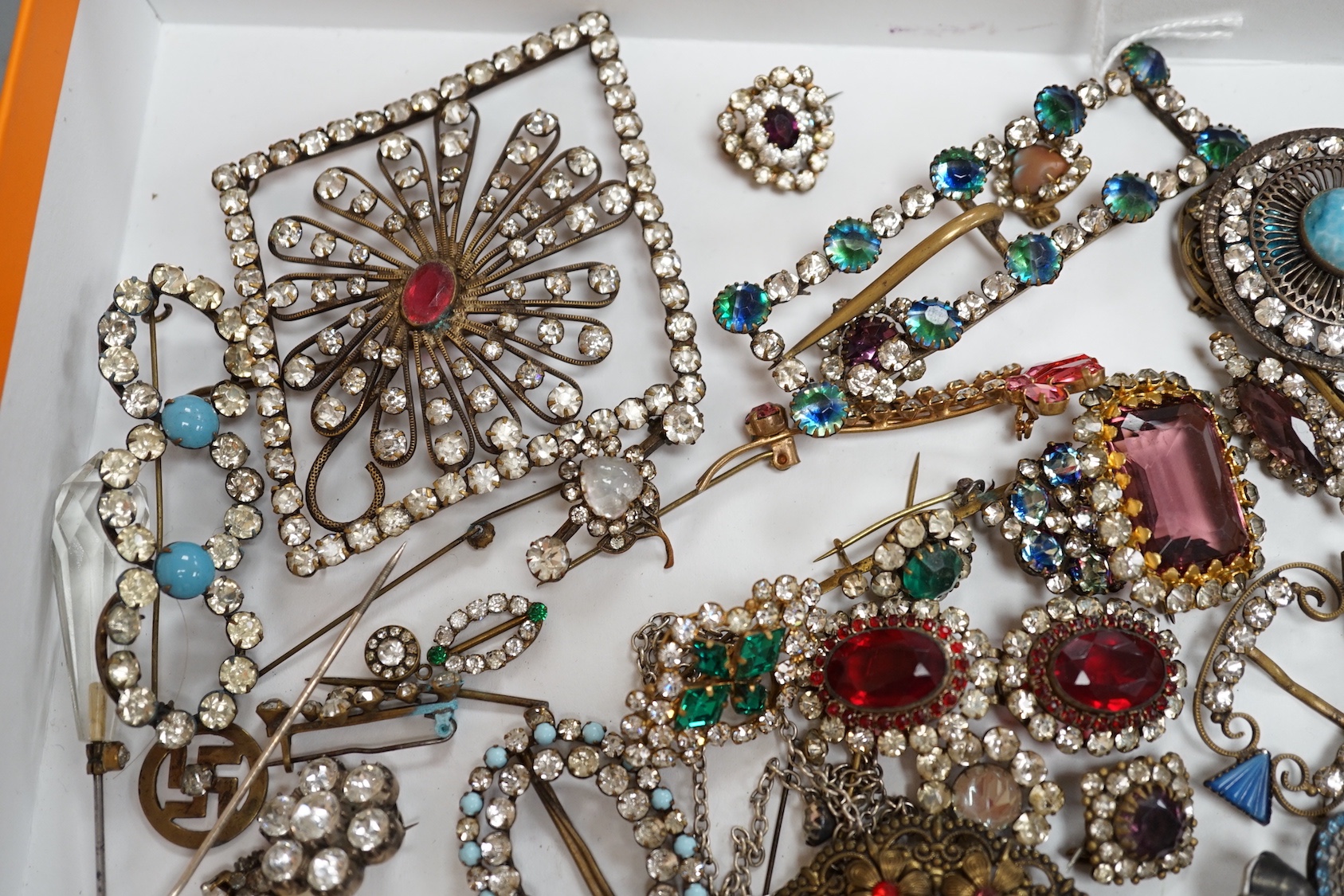 A quantity of assorted coloured and white paste jewellery, including brooches and buckles.